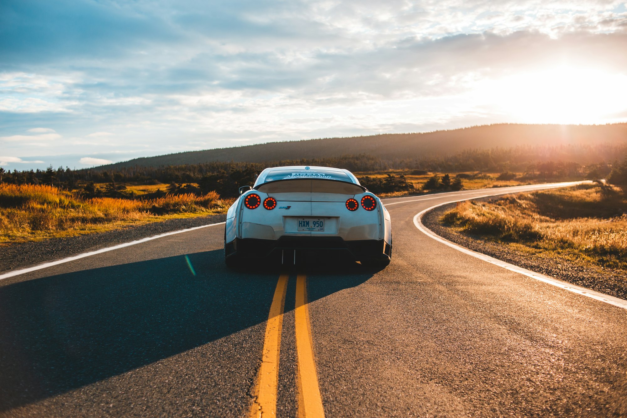Nissan GT-R grise sur une route sinueuse au coucher du soleil